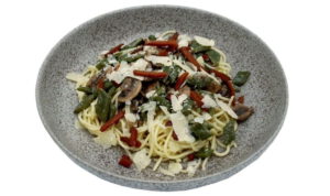 Vegetarische pasta op een bord met groente en Parmezaan